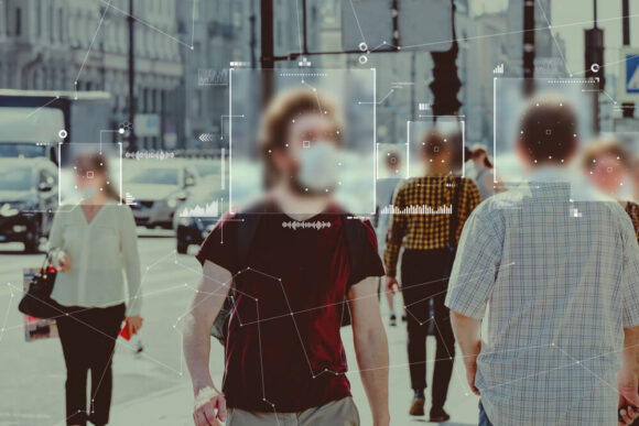 People walking down the street, several wearing masks, with graphics over their faces analyzing their features